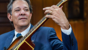 Haddad tocando violão - imagem artigo tributação dólar e inflação